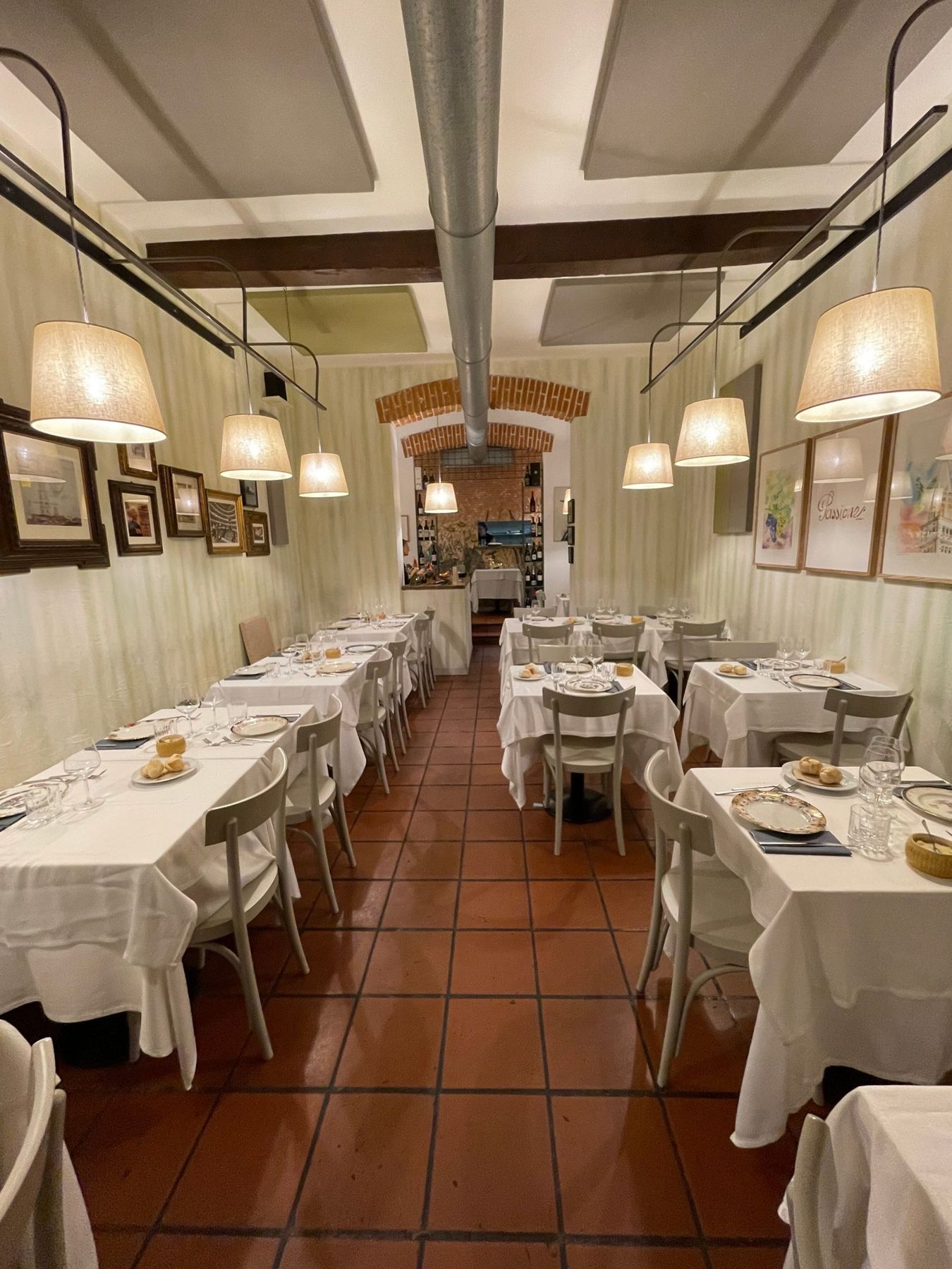 La sala del Ristorante Aurora: tavoli apparecchiati con tovaglie bianche, pavimento in cotto e volta in mattoni